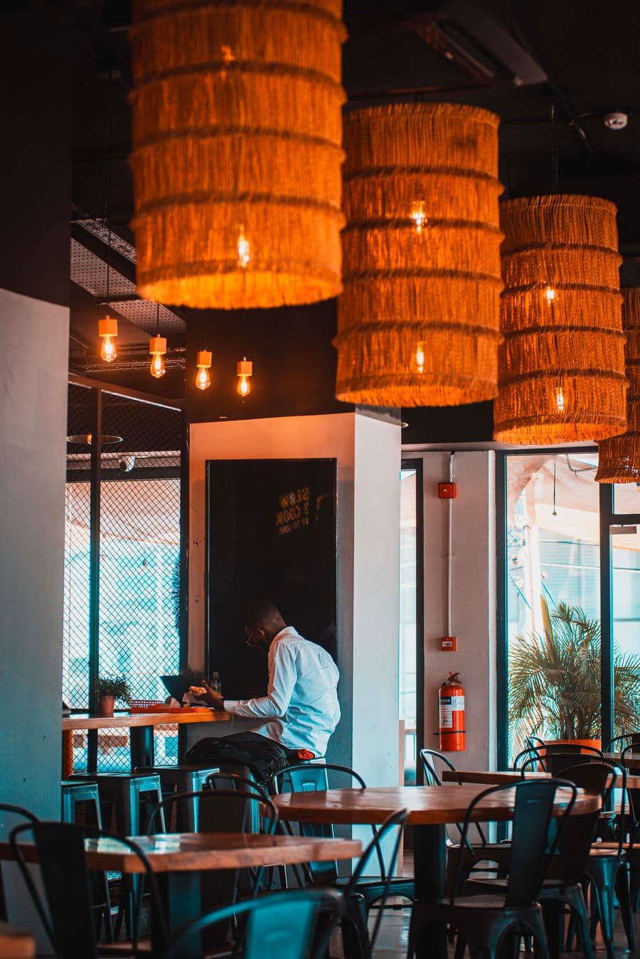 Salle de restaurant chaleureuse avec suspensions en osier